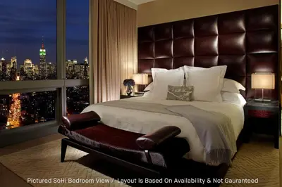 a bedroom with a large bed with a large window at The Dominick Hotel in New York