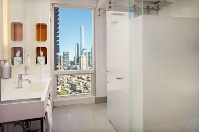 a bathroom with a view of a city from a window at YOTEL New York Times Square in New York