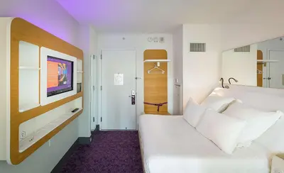 a bedroom with a white bed and a tv at YOTEL New York Times Square in New York