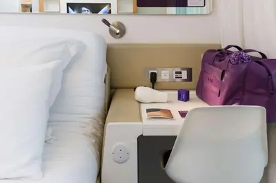 a room with a bed and a backpack and a table at YOTEL New York Times Square in New York