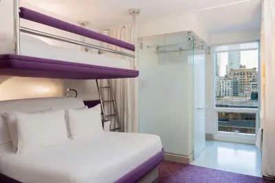 a bedroom with two bunk beds and a window at YOTEL New York Times Square in New York