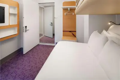 a bedroom with a large white bed and a tv at YOTEL New York Times Square in New York