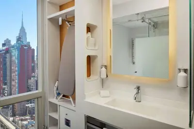 a bathroom with a sink and a window at YOTEL New York Times Square in New York