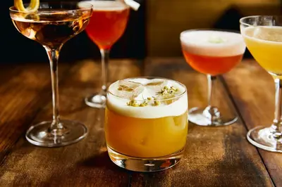four glasses of different types of drinks on a wooden table at Kimpton Hotel Eventi by IHG in New York