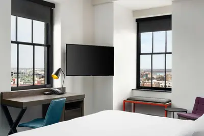 a bedroom with a bed and a desk with a tv at Aloft Philadelphia Downtown in Philadelphia