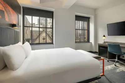 a bedroom with a large white bed and a desk at Aloft Philadelphia Downtown in Philadelphia