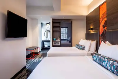 a hotel room with two beds and a flat screen tv at Aloft Philadelphia Downtown in Philadelphia