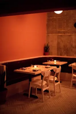 a dining room with two tables and chairs and a bench at Nolitan Hotel SoHo - New York in New York