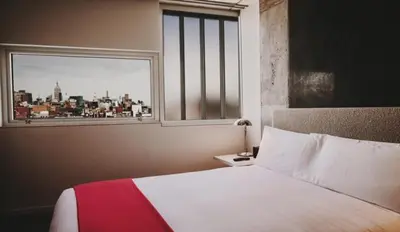 a bedroom with a bed and a window with a view at Nolitan Hotel SoHo - New York in New York