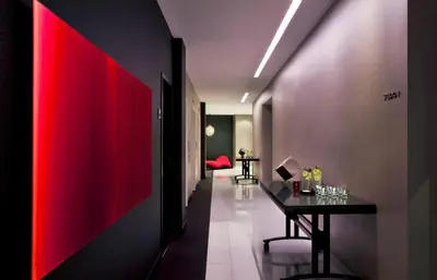 a hallway with a red accent wall and a table at The Washington Hotel NYC in New York