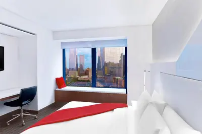 a bedroom with a bed and a window with a view at The Washington Hotel NYC in New York