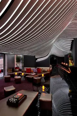 a lobby with couches and tables and a large ceiling at The Washington Hotel NYC in New York
