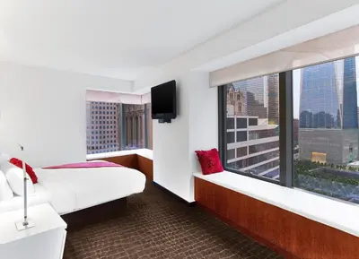 a hotel room with a bed and a large window at The Washington Hotel NYC in New York