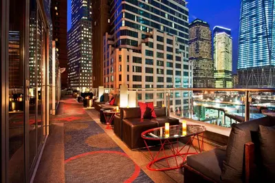 a balcony with couches and tables and a city skyline at The Washington Hotel NYC in New York