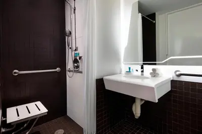 a bathroom with a white sink and a mirror at The Washington Hotel NYC in New York