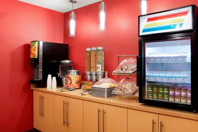 a counter with a refrigerator next to a red wall at TownePlace Suites by Marriott Harrisburg Hershey in Harrisburg