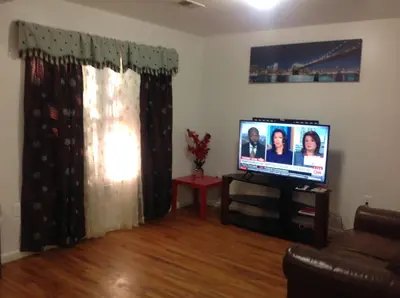 a living room with a flat screen tv and a couch at Mojoy Homesuites At Runyon in Newark
