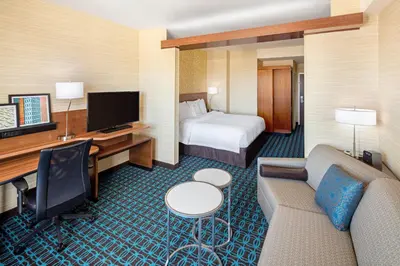 a hotel room with a bed and a couch and a television at Fairfield Inn & Suites by Marriott North Bergen in North Bergen