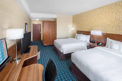 a hotel room with two beds and a flat screen tv at Fairfield Inn & Suites by Marriott North Bergen in North Bergen