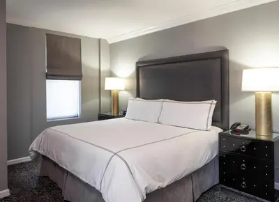a bedroom with a large white bed with two lamps at The Manhattan Club in New York