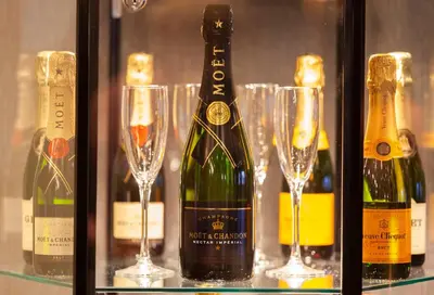 a group of wine bottles and glasses on a shelf at The Manhattan Club in New York