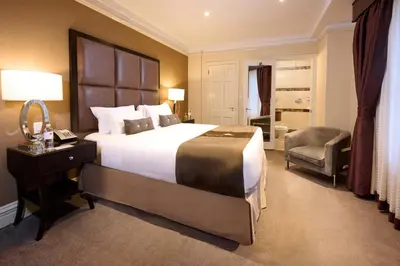 a hotel room with a large bed and a chair at Fitzpatrick Manhattan in New York