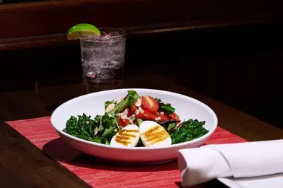 a bowl of salad on a table with a drink at Fitzpatrick Grand Central in New York