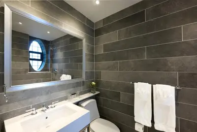 a bathroom with a sink and a toilet and a mirror at Fitzpatrick Grand Central in New York