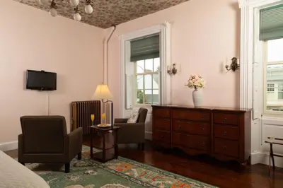 a bedroom with a dresser and chairs and a tv at Carlisle House Bed and Breakfast in Carlisle