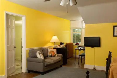 a living room with yellow walls and a couch at Carlisle House Bed and Breakfast in Carlisle