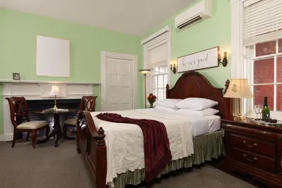 a bedroom with a large bed and a desk and a table at Carlisle House Bed and Breakfast in Carlisle