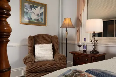 a bedroom with a chair and a lamp and a bed at Carlisle House Bed and Breakfast in Carlisle