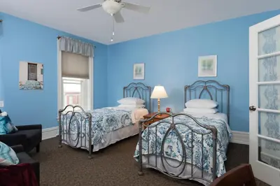 two beds in a room with blue walls at Carlisle House Bed and Breakfast in Carlisle