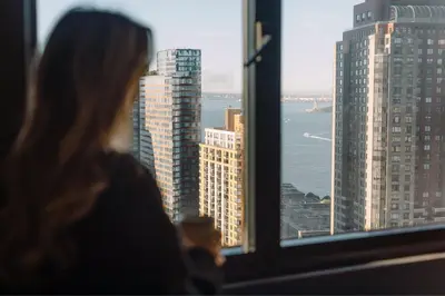 a woman looking out of a window at a city at New York Marriott Downtown in New York