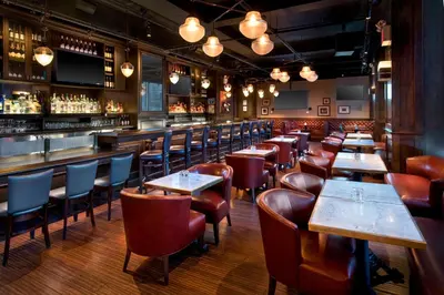 a restaurant with wooden tables and chairs and a bar at New York Marriott Downtown in New York