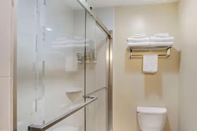 a bathroom with a shower and a toilet and towels at Best Western Monticello in Monticello