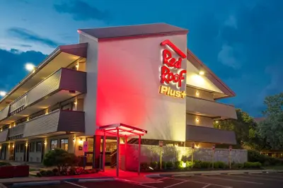 a building with a red fist sign in front of it at Red Roof Inn PLUS+ Secaucus - Meadowlands in Secaucus
