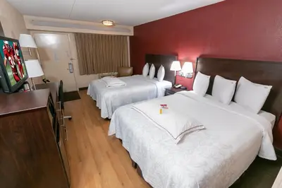 a hotel room with two beds and a flat screen tv at Red Roof Inn PLUS+ Secaucus - Meadowlands in Secaucus