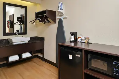 a bathroom with a sink and a vanity with a mirror at Red Roof Inn PLUS+ Secaucus - Meadowlands in Secaucus