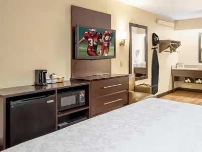 a hotel room with a bed and a flat screen tv at Red Roof Inn PLUS+ Secaucus - Meadowlands in Secaucus