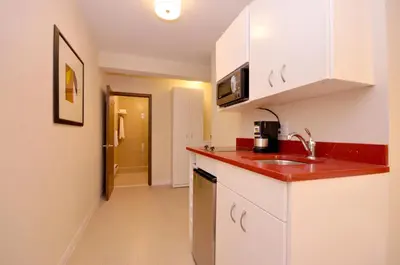 a kitchen with white cabinets and a red counter top at Hotel Five44 in New York