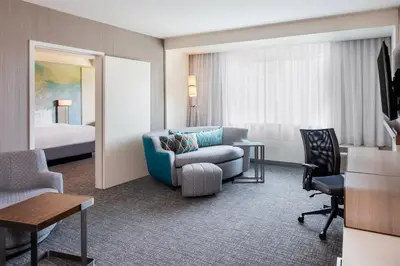 a hotel room with a couch chair and a bed at Courtyard by Marriott Wayne Fairfield in Wayne