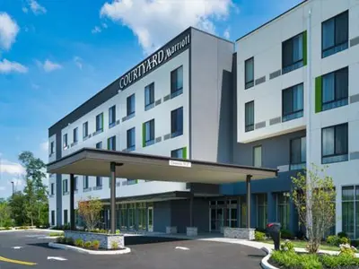 a large white building with a sign on it at Courtyard by Marriott Deptford in Almonesson