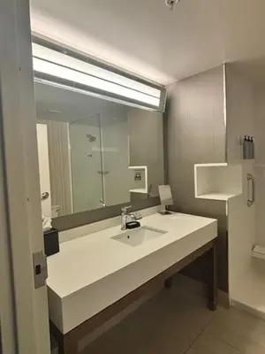 a bathroom with a sink and a large mirror at Courtyard by Marriott Deptford in Almonesson
