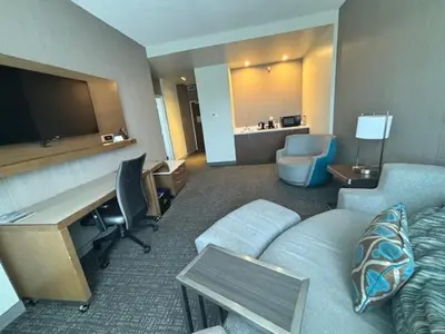 a hotel room with a couch and a desk with a desk at Courtyard by Marriott Deptford in Almonesson