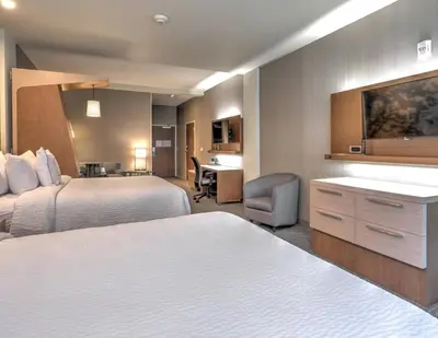 a hotel room with two beds and a desk at Courtyard by Marriott Deptford in Almonesson