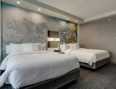 a bedroom with two beds and a painting on the wall at Courtyard by Marriott Deptford in Almonesson