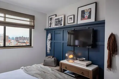a bedroom with a blue accent wall and a tv at Redford Hotel in New York