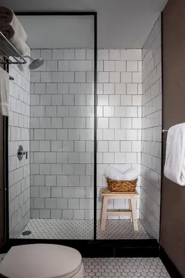 a bathroom with a shower with a basket on a stool at Redford Hotel in New York