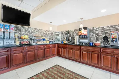 a bar with wooden cabinets and a flat screen tv at Days Inn & Suites by Wyndham York in York